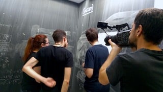 cameraman is filming students writing formulas on a big blackboard in Bilbao